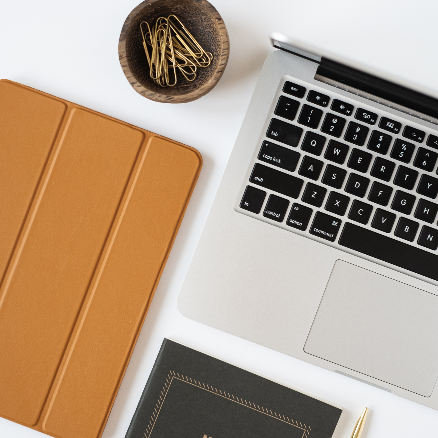 5 Things You Must Include in Your Business Coaching Contract - Flatlay image of computer, tablet in a brown leather case and notebook